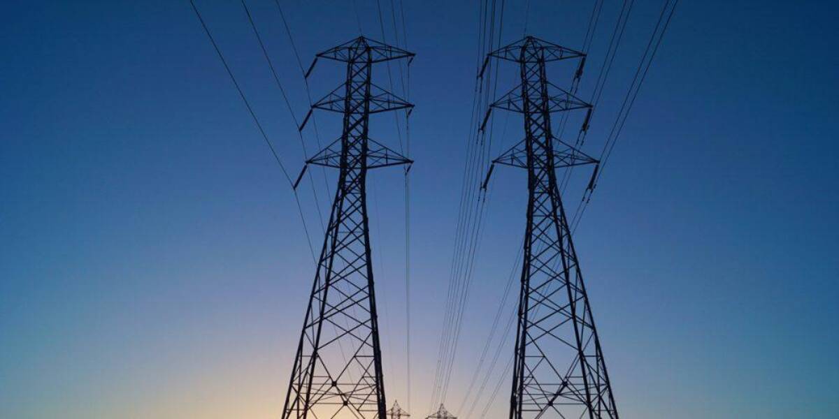 Electricity transmission towers against an evening sky